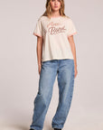 Full body front view of a woman wearing the Chaser Avec Le Band Tee and sneakers on a neutral background
