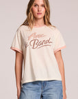 Front view of a woman wearing the Chaser Avec Le Band Tee and jeans on a neutral background