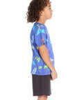 Side view of the Chaser Kids Cyber Surfer Tee in blue featuring colorful ocean and gaming graphics extending across the side