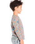 Side view of boy wearing Chaser’s Hockey Champ patterned long-sleeve top against a white background
