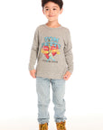 Full body view of boy wearing Chaser’s Tom Petty Live On Tour gray long-sleeve top with a broken heart and guitar graphic design and light blue jeans on a white background