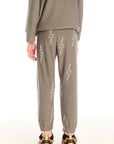 Back view of boy wearing Chaser's green Allover Bolts Pants with lightning bolt designs on a white background