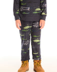 Boy wearing Chaser's dark gray Allover Helicopters pant with green airplane patterns and matching top on a white background