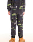 Back view of boy wearing Chaser's dark gray Allover Helicopters pant with green airplane patterns and matching top on a white background
