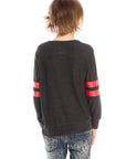Back view of boy wearing Chaser’s Best Brother Ever black long-sleeve shirt with striped sleeves, paired with blue jeans on a white background