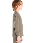 Side view of boy wearing Chaser’s Bolt safari green long sleeve top with lightning bolt design and matching pants on a white background.