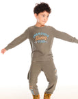 Full body view of boy wearing Chaser’s Safari Green Champions Racing Team long sleeve top with matching pants on a white background