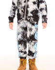 Boy wearing Chaser’s Smiley Bolt tie-dye pants with matching zip up hoodie on a white background