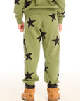 Back view of boy wearing Chaser's Allover Stars green pant with black star patterns on a white background