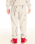 Back view of boy wearing Chaser's gray Allover Bolts pants with lightning bolt designs and on a white background