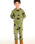 Full view of boy wearing Chaser's Allover Stars green hoodie and matching pants with black star patterns on a white background