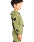 Side view of boy wearing Chaser's Allover Stars green hoodie and matching pants with black star patterns on a white background