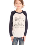 Front view of boy wearing Chaser’s The Beatles Abbey Road football tee in white with navy blue sleeves and jeans on a white background