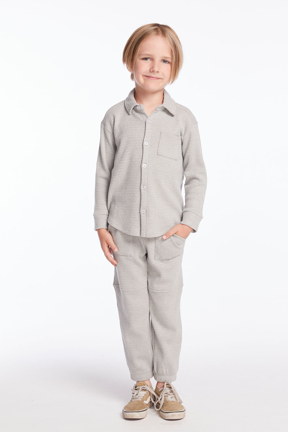 Full body view of boy wearing Chaser’s heather grey Knee Seam Joggers with waffle texture and matching top on a white background