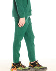 Side view of boy wearing Chaser’s Everest Green Knee Seam Jogger with relaxed fit and knee seam detail on a white background