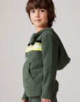 Model wearing Chaser's Lime Stripe Boys Zip-Up Hoodie in leafy green with striped detailing, side view