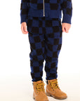 Front view of boy wearing Chaser’s blue checkered Lounge Pant with Pocket against a white background