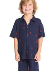 Front view of boy wearing the Chaser Kids Collared Avalon Lobsters Shirt in navy blue with red embroidered lobster motifs, paired with matching Avalon Lobsters Cozy Beach Shorts on a white background