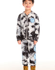 Full body view of boy wearing Chaser’s Smiley Bolt tie-dye zip up hoodie with matching pants on a white background