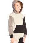 Side view of boy wearing Chaser’s color-blocked long sleeve hoodie with hood up and matching pants on a white background