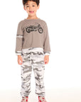 Full body view of boy wearing Chaser’s Camo Pants in gray camouflage with matching Moto Rider top on a white background.