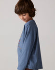 Model wearing Chaser's Champions Boys Long Sleeve Tee in blueberry jam with distinctive graphic and design details, side view