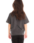 Back view of young girl wearing Chaser’s Best Sister black tee on a white background