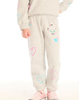 Girl wearing Chaser’s light gray Winter Love Pants with colorful designs on a white background