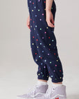 Model wearing Chaser's Festive Lights Girls Pants in Avalon with distinctive graphic and design details, side view
