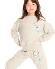 Girl wearing Chaser’s light gray Winter Love Stitches Long Sleeve with colorful designs on a white background