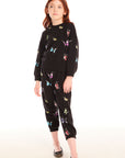 Full body view of young girl wearing Chaser’s Butterfly Love black long sleeve pullover with colorful butterfly patterns and matching pants on a white background
