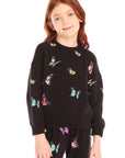 Young girl wearing Chaser’s Butterfly Love black long sleeve pullover with colorful butterfly patterns on a white background