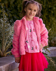 Chaser Kids Camelia Girls Puff-Sleeve Jacket in pink plush fabric, worn open, front view outdoors beside a low wall and greenery