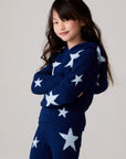 Model wearing Chaser's Allover Stars Girls Hoodie in lake blue with star detailing, side view