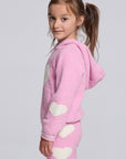 Chaser Kids Holiday Hug Girls Hoodie in pink with white hearts, side view on a model against a light gray studio background