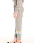 Side view of girl wearing Chaser’s Heather Grey Contrast Strappings Pants with colorful accents on the left leg on a white background