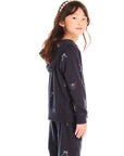 Side view of girl wearing Chaser’s navy blue Tossed Glitter Bows Zip Up Hoodie with embroidered bows on a white background