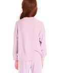 Back view of girl wearing Chaser’s pink Rainbow Glitter Heart Pullover with rainbow heart design on a white background