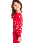 Side view of girl wearing Chaser’s Danni Rouge Pullover with star patterns and matching Tara Leggings on a white background