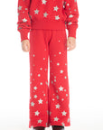 Girl wearing Chaser’s Tara Rouge Leggings with star patterns and matching Danni Rouge Pullover on a white background
