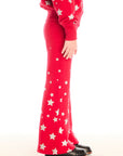 Side view of girl wearing Chaser’s Tara Rouge Leggings with star patterns and matching Danni Rouge Pullover on a white background