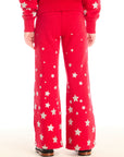 Back view of girl wearing Chaser’s Tara Rouge Leggings with star patterns and matching Danni Rouge Pullover on a white background