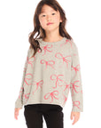 Girl wearing Chaser’s gray Red Bows Long Sleeve with pink bow pattern on a white background