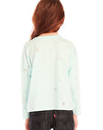 Back view of young girl wearing Chaser’s Ciao Allover Stars light green pullover with light grey star patterns and dark jeans on a white background