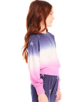 Side view of girl wearing Chaser’s Glitter Stars Ombre Tie Dye Long Sleeve with colorful star patterns and matching pants on a white background