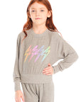 Girl wearing Chaser’s Rainbow Bolts Pullover in heather grey with colorful lightning bolt designs on a white background