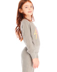 Side view of girl wearing Chaser’s Rainbow Bolts Pullover in heather grey with colorful lightning bolt designs on a white background