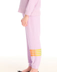 Side view of girl wearing Chaser’s pink Rainbow Glitter Pants with rainbow heart design on a white background