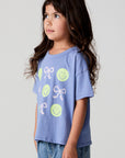 Side view of a girl wearing the Chaser Happy Bows Tee on a neutral background