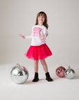 Model wearing Chaser's Merry Girls Long Sleeve Tee in white with holiday lettering, editorial view